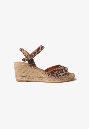 Espadrilke na platformi z leopardjim vzorcem, z osnovo iz jute vrvi, nastavljivim trakcem okoli gležnja, odprtom toe dizajnom in teksturiranim zgornjim delom iz blaga.