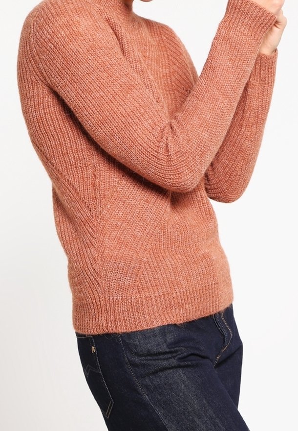Svetr v hnědo-oranžové barvě, pletený, s vysokým výstřihem, žebrovou texturou a dlouhými rukávy, doplněný tmavými džíny.