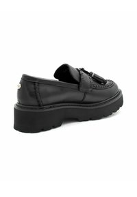 Mocassins noirs avec une semelle épaisse et texturée. Présente un design tressé et des glands décoratifs. Partie supérieure en cuir lisse avec des accents cousus.