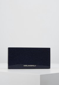 Navy blue rectangular box with a sparkling texture, featuring a silver "KARL LAGERFELD" logo on the front. Smooth, glossy finish.