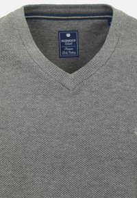 Szary sweter z dzianiny w serek, z ribbowanymi mankietami i dolnym brzegiem; zawiera niebieską metkę z nazwą marki i szczegółami stylu.