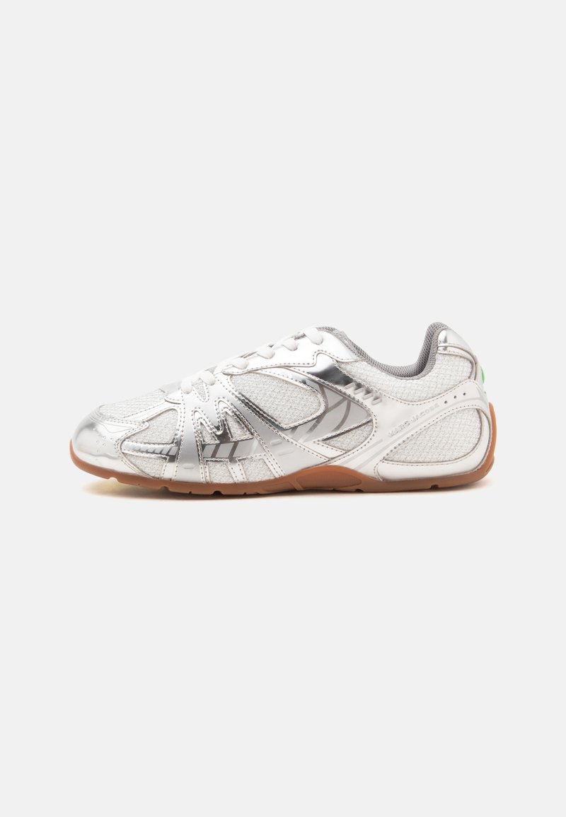 Chaussure de sport blanche et argentée avec panneaux en mesh et semelle en gomme, vue de côté sur fond blanc.