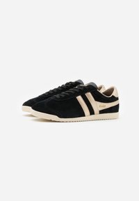 Scarpe sneakers in suède nero con strisce e dettagli beige. La suola è testurizzata e di colore crema. Presenta un design con lacci e un dettaglio del logo.