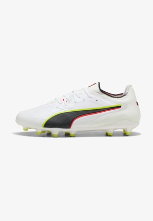 Valkoinen jalkapallokengän naula, jossa mustia, neonkirkkaita vihreitä ja punaisia yksityiskohtia, nauhat ja muotoillut nastat pohjassa hyvin kovalle kentälle.