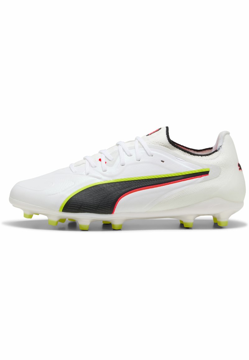 Valkoinen jalkapallokengän naula, jossa mustia, neonkirkkaita vihreitä ja punaisia yksityiskohtia, nauhat ja muotoillut nastat pohjassa hyvin kovalle kentälle.