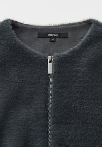 Giacca in eco-pelliccia grigia scura con scollatura rotonda, caratterizzata da una chiusura con zip argentata sul davanti e un'etichetta con la scritta "someday" di taglia 36.