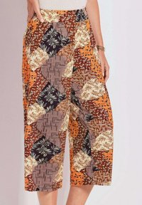 Kleurrijke culottes met patronen in verschillende tinten oranje, bruin en crème, met opvallende geometrische en bloemdesigns. Lengte tot halverwege de kuit.