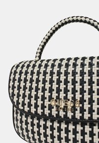 Borsa intrecciata in bianco e nero, caratterizzata da una forma strutturata, un logo in oro ben visibile e una maniglia intrecciata.
