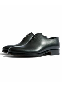 Chaussures en cuir noir à lacets avec une finition lisse, bout rond et un petit talon en bois. Présente six œillets pour les lacets.