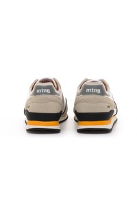 Un par de zapatillas de deporte beige y blancas con acentos en la suela de color amarillo y negro, vistas desde atrás, mostrando la marca "mtng." y el detalle "1967".