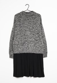 Harmaa ja musta neulemekko, jossa on tekstuuripintainen yläosa ja laskostettu musta hame, suunniteltu pyöreällä pääntiellä ja pitkillä hihoilla.