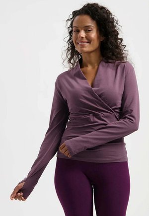Langärmliges Oberteil in gedämpftem Lila, mit einem V-Ausschnitt und Wickeldesign sowie figurnahem Schnitt. Strukturierter Stoff mit Daumenlochärmeln und glatter Oberflächenbeschaffenheit.