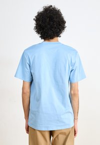 Light blue cotton t-shirt with short sleeves and a crew neckline. Smooth texture, relaxed fit, and no visible graphics or patterns.