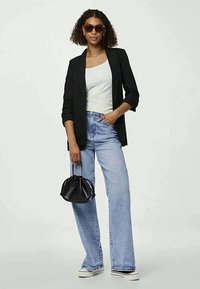 Musta bleiseri valkoisen tanktopin päällä, vaaleansiniset leveälahkeiset farkut, valkoiset koroketossut ja pieni musta laukku. Asusteina aurinkolasit.