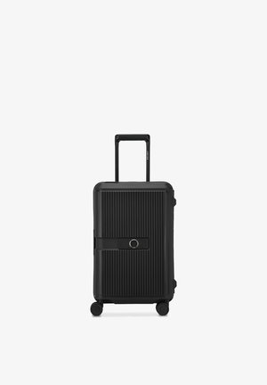 Valigia rigida nera con scanalature verticali, quattro ruote, manico retrattile e serratura a combinazione integrata su sfondo bianco.