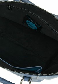 Blauwe leren handtas met een ritsluiting, met een interieur van zwarte stof en een label aan de binnenzijde. Smooth textuur met een ronde vorm.