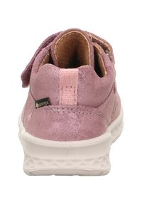 Rosa Wildlederkinderschuh mit Klettverschluss, weißer Gummisohle und strukturiertem Innenbereich. Gore-Tex-Branding auf der Seite sichtbar.