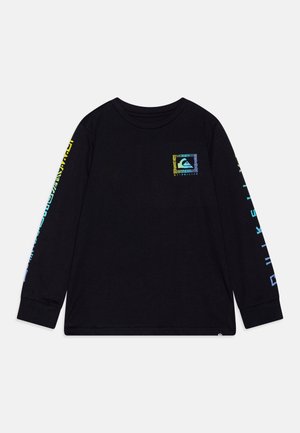 Camiseta de manga larga negra con un parche de logo colorido en el pecho y gráficos audaces a lo largo de las mangas en verde y azul.