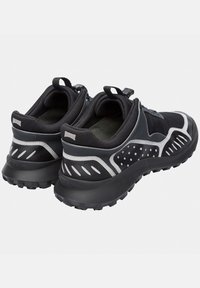 Czarne sportowe buty z teksturowaną cholewką z tkaniny, srebrnymi akcentami i wytrzymałą podeszwą. Wyposażone w pętlę do ściągania i oddychającą siateczkową wyściółkę.