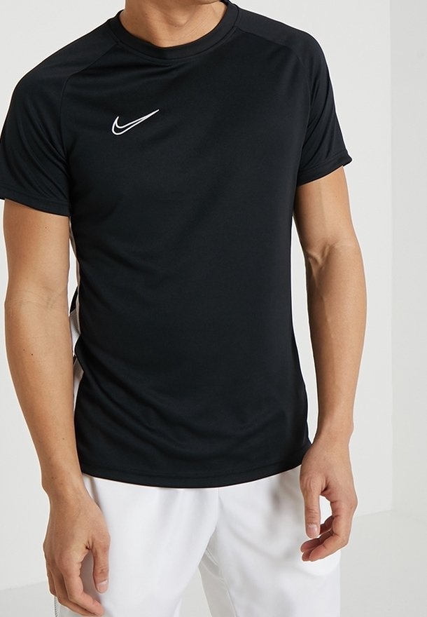 T-shirt de sport noir en tissu extensible, doté d'un col rond, de manches courtes et d'un logo Nike blanc sur la poitrine.