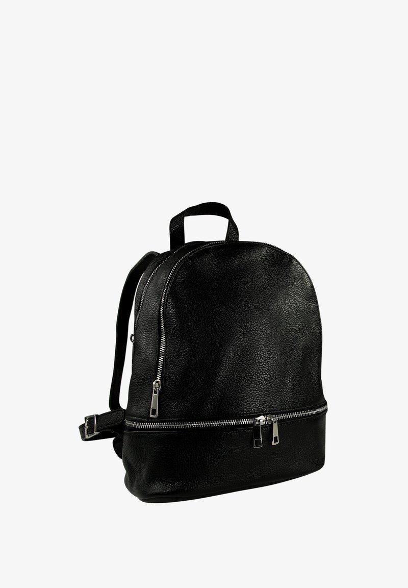 Sac à dos en cuir noir avec une forme arrondie, présentant deux compartiments zippés argentés et des bretelles rembourrées et ajustables. Surface texturée.