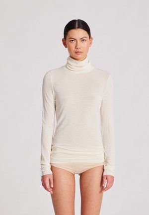 Maglia a maniche lunghe con collo alto in crema, realizzata in tessuto leggero con una texture liscia; presenta una silhouette aderente e dettagli di orlo arricciato.