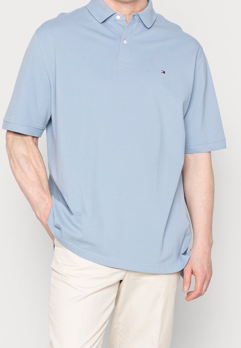 Polo shirt bleu clair en coton, avec un col, des manches courtes et un petit logo brodé sur la poitrine gauche.