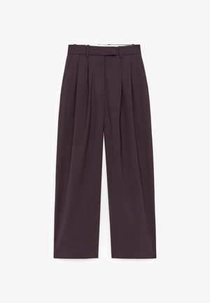 Tummanruskeat leveälahkeiset housut, joissa on laskokset, vyölenkit, sivutaskut ja piilotettu etukiinnitys.