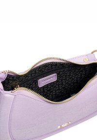 Sac à main en cuir lilas avec un extérieur texturé, des accessoires dorés et un dessus zippé. L'intérieur présente une doublure noire à motif et une poche intérieure.