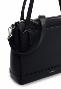 Czarna skórzana torebka o fakturowanej powierzchni, z zamkiem błyskawicznym na górze, ozdobami w postaci frędzli oraz srebrnymi elementami metalowymi. Posiada podwójne uchwyty.