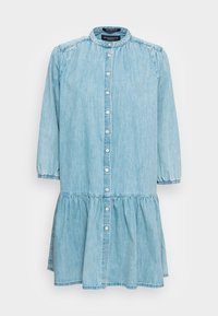 Ljusblå denimklänning med samlad midja, långa ärmar, knapplist fram och utsvängd nederkant. Har en rundad krage och elastiska ärmslut.