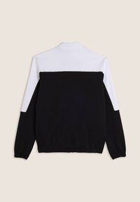 Sudadera en blanco y negro con un cuello alto, con un diseño de bloques de color. Tela suave con puños y dobladillo elásticos para un ajuste ceñido.