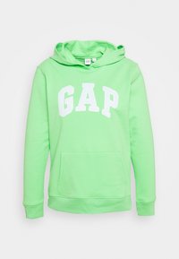 Zelená mikina s kapucí a přední kapsou, s bílým logem "GAP". Vyrobena z měkkého materiálu, má stahovací kapuci a žebrované manžety.