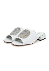 Mule bianche con punta aperta, decorate con un embellishment in argento strutturato e un tacco basso a blocco. Materiale sintetico liscio con un design semplice.