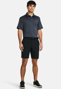 Polo gri închis cu mânecă scurtă și o textură subtilă în dungi, purtat cu pantaloni scurți negri și pantofi sport negri. Inclusiv curea.