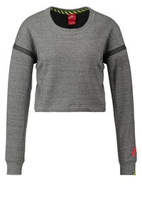 Grå kortärmad sweatshirt gjord av mjukt material. Har långa ärmar med svarta detaljer och en röd logotyp på ärmen. Cirkulär halsringning.