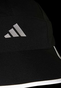 Gorra deportiva negra con un tejido texturizado, acentos en blanco y un logo plateado de tres franjas en la parte frontal. Visera con un borde contrastante.
