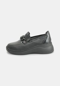 Scarpe slip-on nere con punta arrotondata, tomaia in pelle texture, accenti decorativi sul davanti e suola spessa e imbottita.