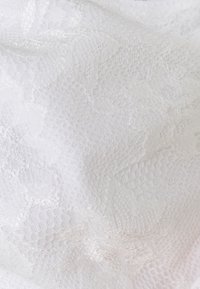 Hvit blonderstoff med intrikate blomstermønstre, som har en myk, teksturert overflate og et lett, semitransparent utseende.