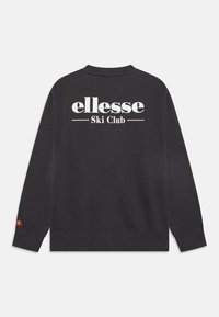 Felpa nera con maniche lunghe, caratterizzata da "ellesse Ski Club" in bianco sul retro e un logo decorativo sulla manica. Tessuto elastico e testurizzato.