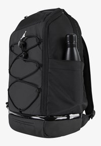 Black backpack featuring a textured fabric, elastic cord detail on the front, and a side pocket with a black water bottle.