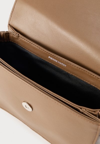 Ανοιχτό καφέ δερμάτινο πορτοφόλι που δείχνει μαύρο εσωτερικό και ασημένια κούμπωμα με κουμπί, με το λογότυπο «Pierre Hardy» στο εσωτερικό.