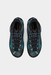 Ζεύγος πεδιλών πεζοπορίας σε τιρκουάζ και μαύρο χρώμα με κορδόνια με σχέδιο, από πάνω σε λευκό φόντο.