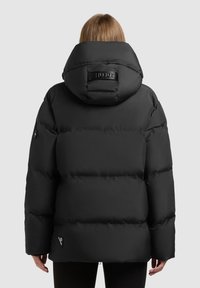 Crna bundica s visokim ovratnikom i brendiranim detaljem na leđima, s glatkom, mat teksturom i rebrastim manžetama.