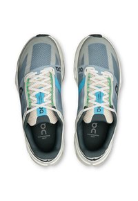 Graue Laufschuhe mit blauen Akzenten und weißen Schnürsenkeln. Obermaterial aus Mesh mit strukturiertem Design. Gepolsterter Kragen und Zunge, sichtbares Markenlogo innen.