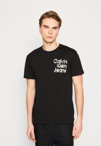 Calvin Klein Jeans STACKED EUPHORIC LOGO TEE - Camiseta estampada - black