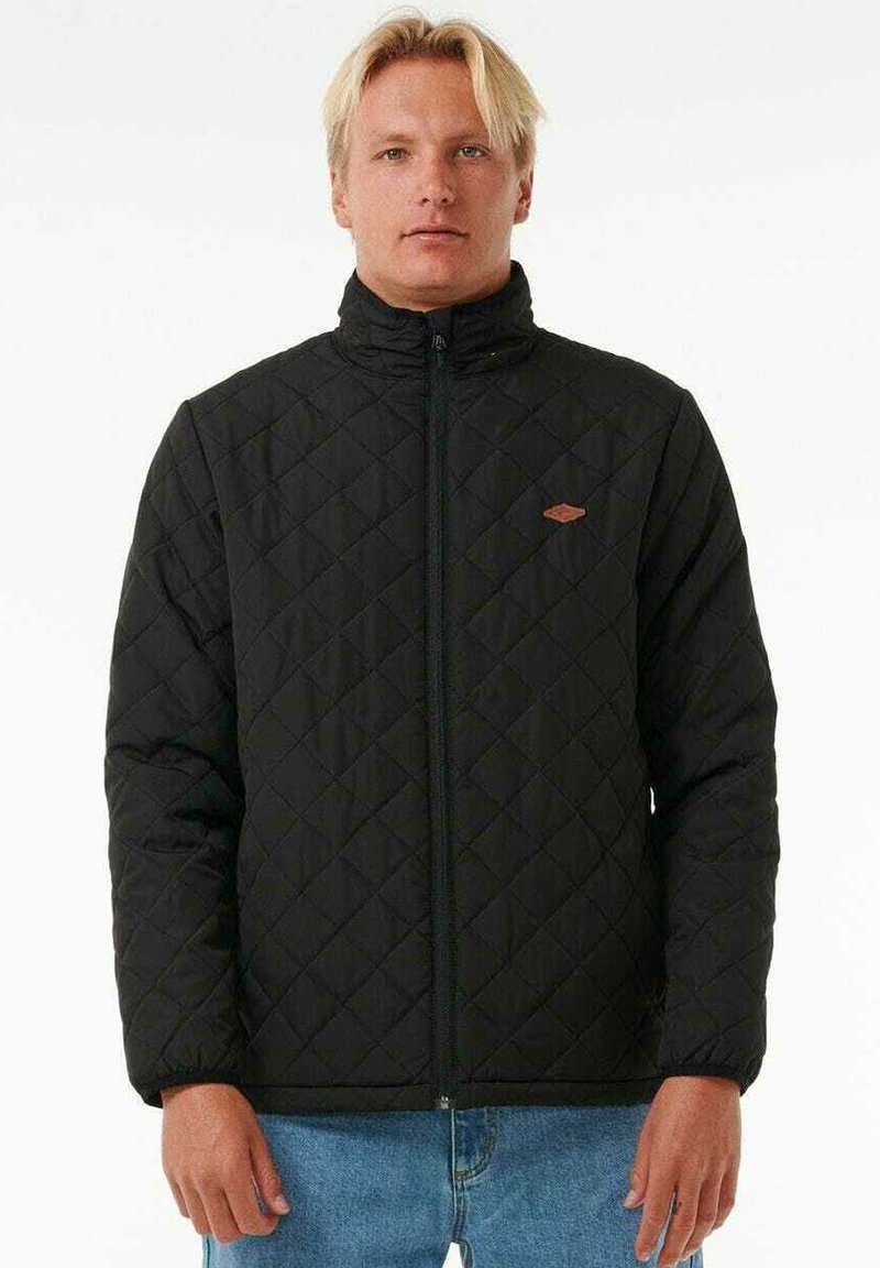 Black quilted jacket with a high collar, featuring a front zipper and a small brown logo detail on the chest. Texture is smooth.