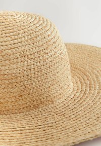 Cappello di paglia a tesa larga con una texture intrecciata naturale e colore beige chiaro, con dettagli in paglia finemente intrecciati e una corona rotonda.