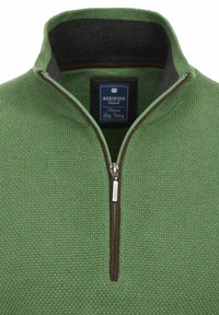 Zielony dzianinowy pulower z zapięciem na zamek przy kołnierzu, teksturowany materiał, kontrastowy ciemny kołnierz i brązowe akcenty wokół zamka. Widoczna metka wewnątrz.