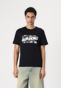 Černé bavlněné tričko s květinovou grafikou v bílé a černé barvě s názvem značky "Jack & Jones." Krátké rukávy a design s kulatým výstřihem.